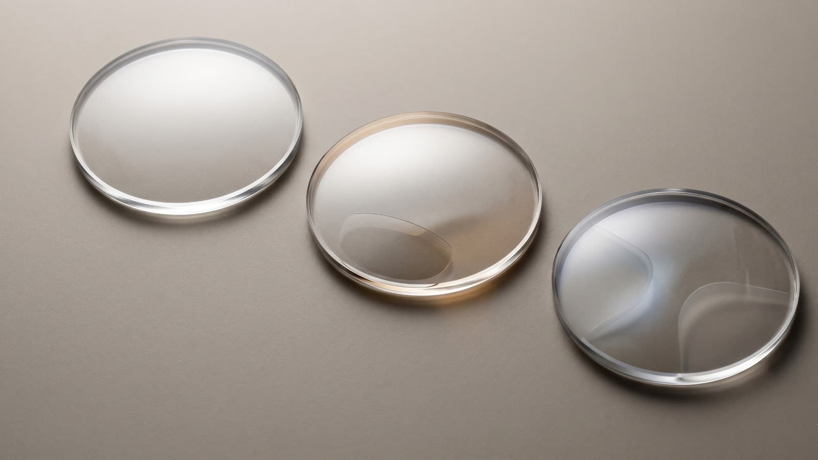 Tres cristales de anteojo en fila, representando lentes para visión lejana, cercana y multifocal
